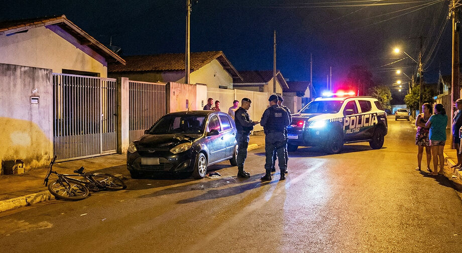 Crie um prompt para gerar uma fotografia extremamente realista, como se tivesse sido registrada por uma Nikon D850 com lente 35mm f/2.8, típica de cobertura policial noturna urbana.  A imagem deve ilustrar uma reportagem sobre discussão de trânsito que te
