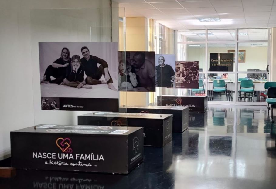 Exposição reúne histórias de famílias formadas pela adoção e segue aberta no Fórum de Dourados até 9 de março.