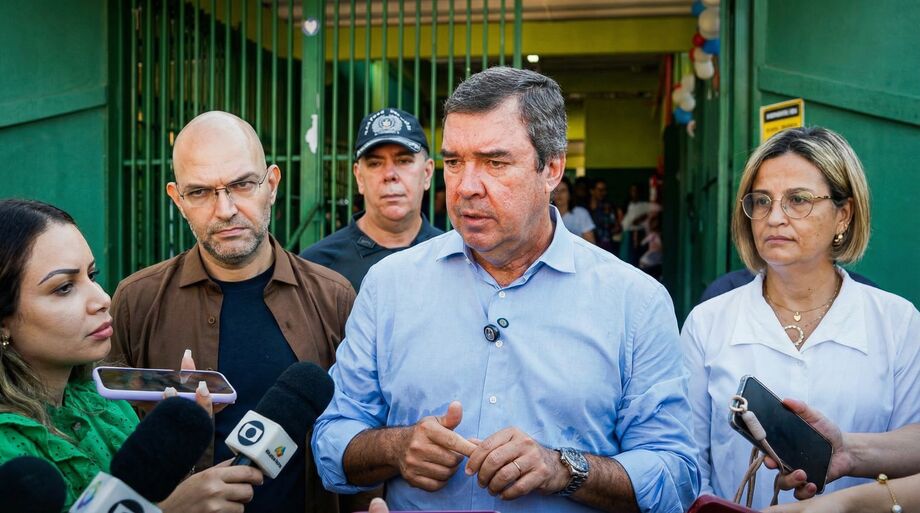 Governador Eduardo Riedel, acompanhado de secretários, fala com a imprensa durante visita à escola em Campo Grande.