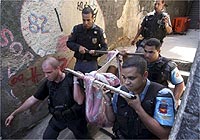 Policiais carregam corpo na favela Santo Amaro, onde houve tiroteio quarta-feira