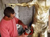 Ique, cartunista campo-grandense da TV Globo (RJ), retocando o bronze da escultura do João Saldanha