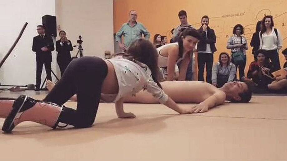 A procuradora ainda diz que a exposição se trata de um homem nu deitado no chão no mesmo ambiente de diversos espectadores, além de uma criança acompanhada da mãe tocando o artista sem qualquer intenção sexual ou libido
