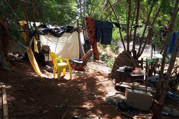 Os barracos na encosta córrego foram destruídos pela correnteza, mas os moradores não desistem de habitar a área de risco