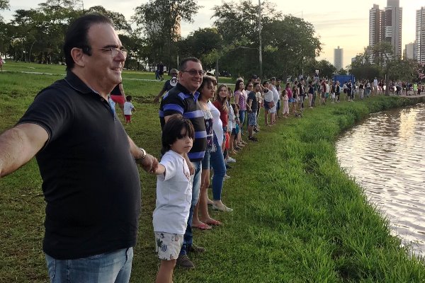 Em abraço ao lago assoreado, Felipe cobra urgência das autoridades.