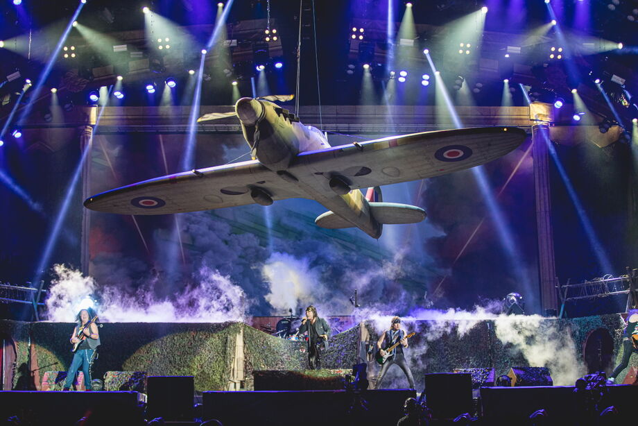 Um avião plana pelo palco sobre a banda