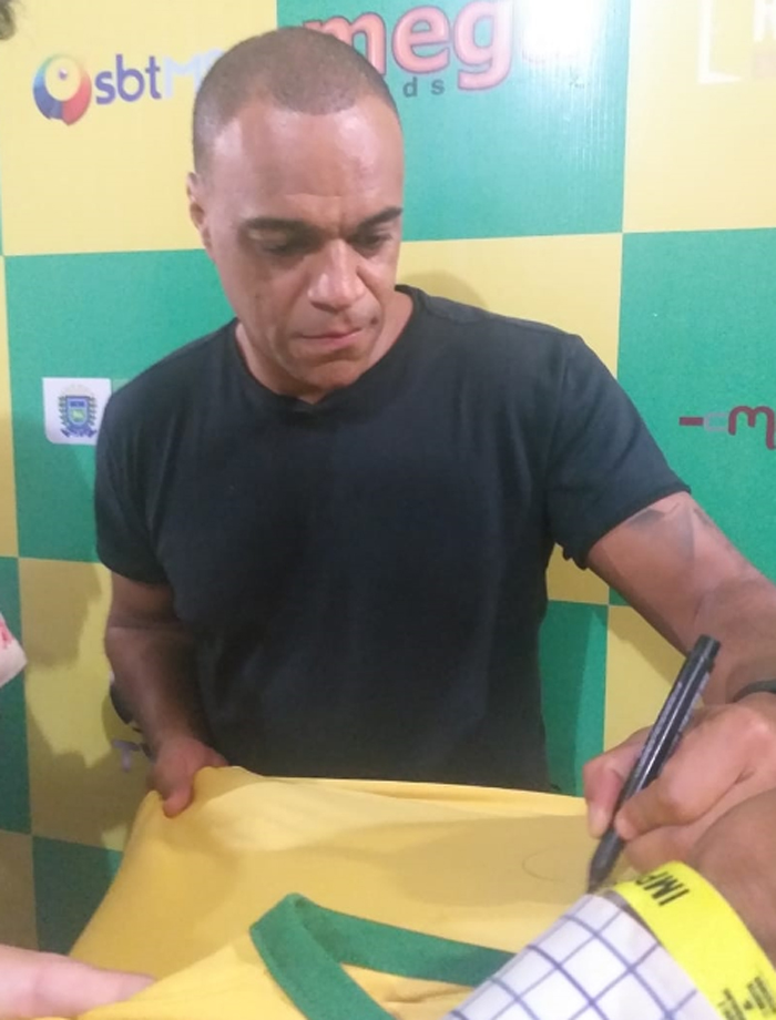 Denílson autografando camiseta da seleção brasileira durante sua passagem a Campo Grande