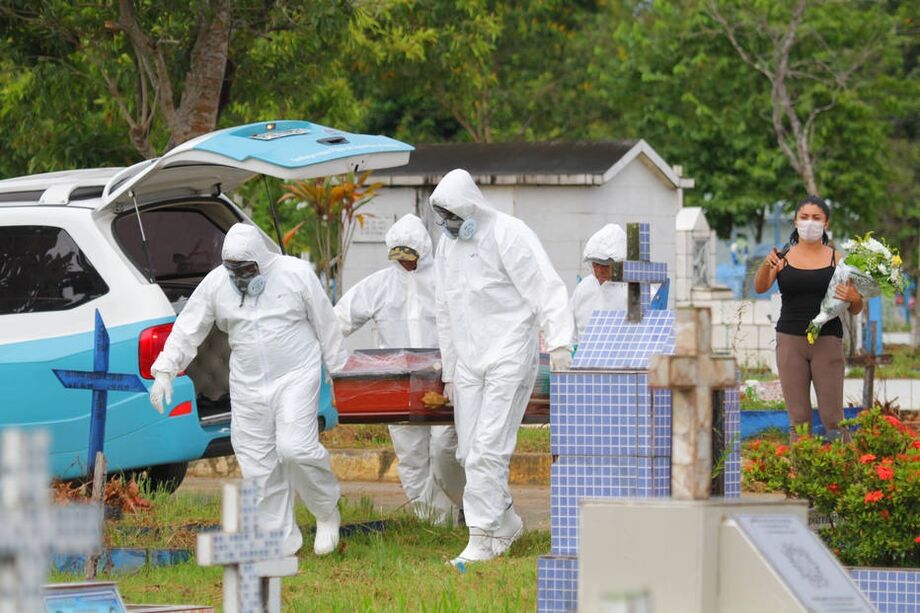 Funcionários utilizam roupa de proteção durante enterro no cemitério Parque Manaus, em Manaus (AM)