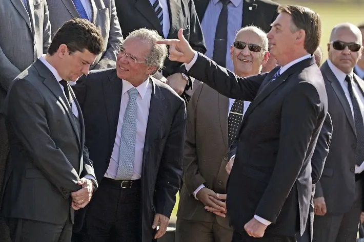 O presidente da República, Jair Bolsonaro, acompanhado dos ministros da Economia, Paulo Guedes, e da Justiça e Segurança Pública, Sergio Moro, na cerimônia de hasteamento da bandeira nacional realizada em frente ao Palácio da Alvorada