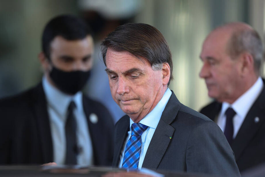 O presidente Jair Bolsonaro; ao fundo, o ministro da Defesa, Fernando Azevedo
