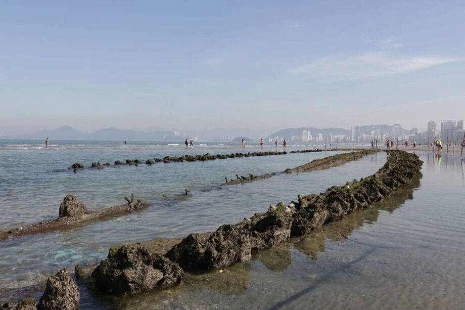 O recuo da maré expôs os destroços de um navio misterioso na faixa de areia da praia