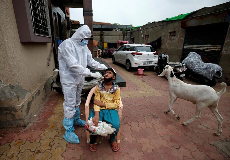 Profissional da saúde faz teste em garoto em meio à pandemia do novo coronavírus em Ahmedabad, na Índia