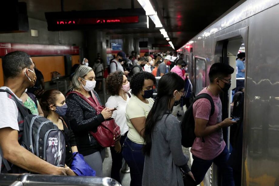 Passageiros com máscaras protetoras se reúnem para entrar no trem em uma estação de metrô em meio ao surto por coronavírus, em São Paulo