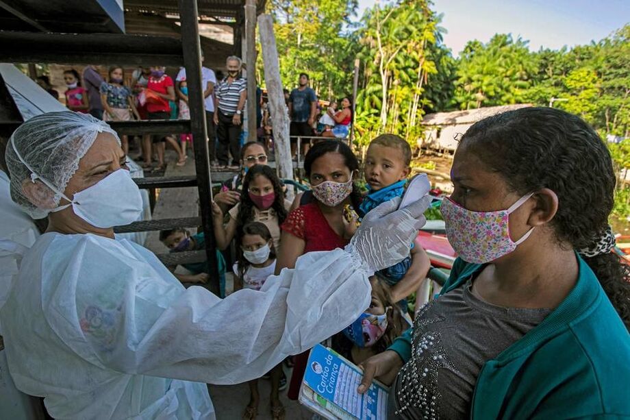 Um profissional de saúde da Unidade de Navios de Assistência Médica UBS verifica a temperatura corporal de um paciente na comunidade ribeirinha de Selma Barra, no rio Buissu, município de Melgaco, na ilha de Marajó, Pará.