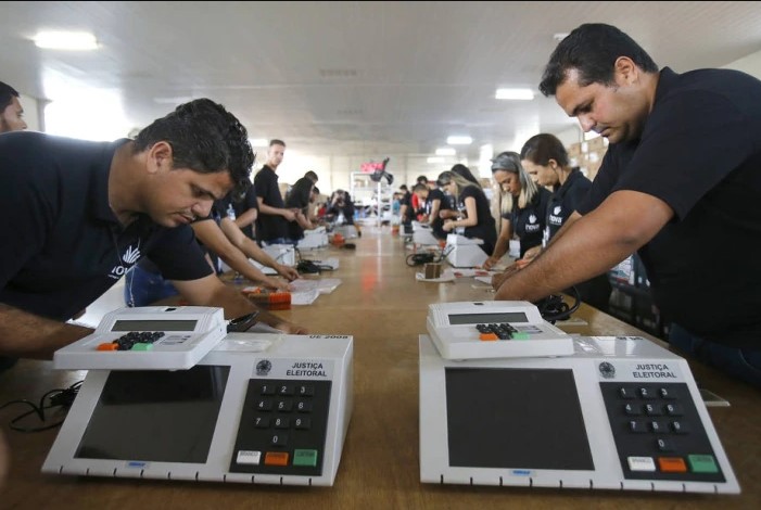Servidores da Justiça Eleitoral preparam urnas eletronicas