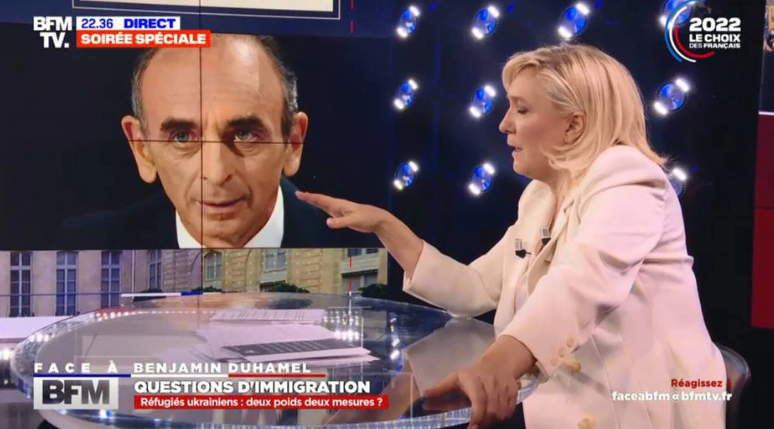 Marine Le Pen foi confrontada com as posições do candidato Éric Zemmour (ao fundo), que elogiou Vladimir Putin. 