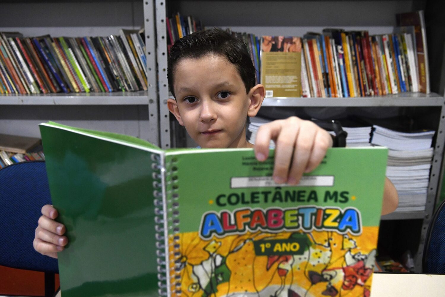 Estudante Benjamim Oliveira com coletânea do MS Alfabetiza
