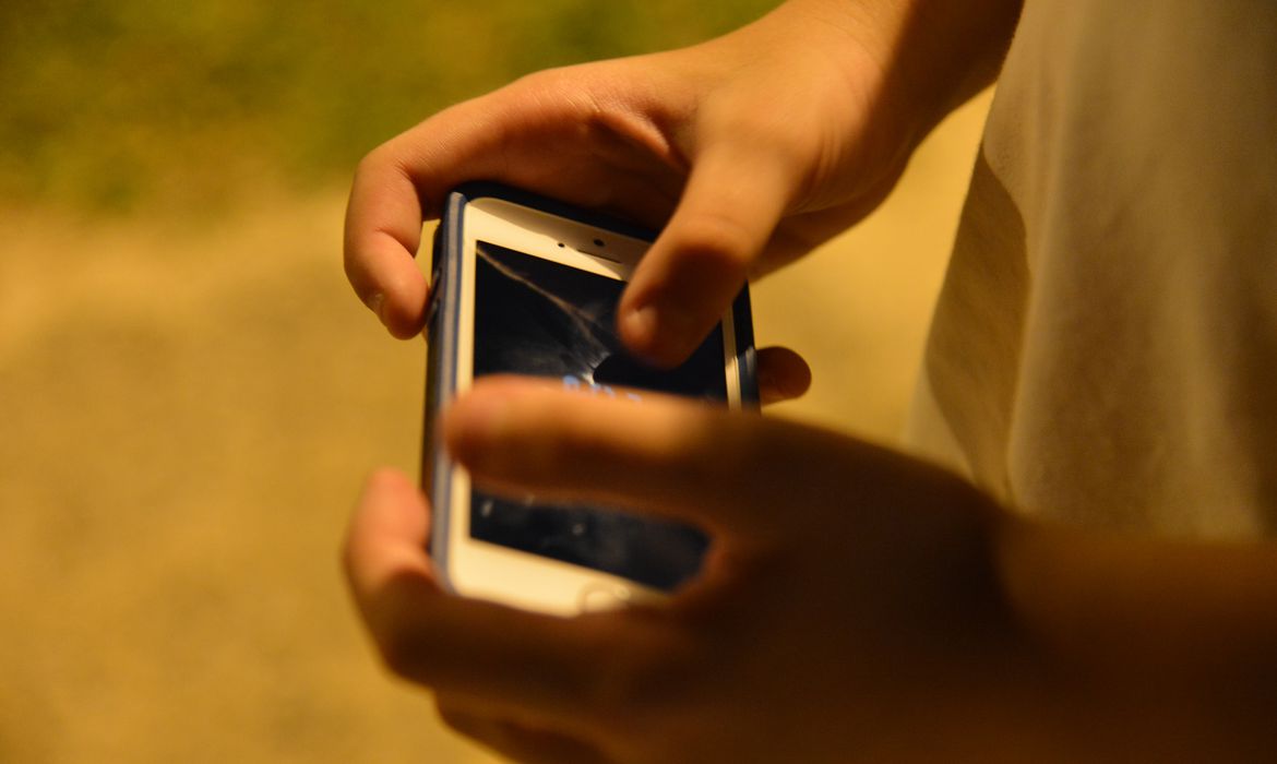 Criança usando o celular.