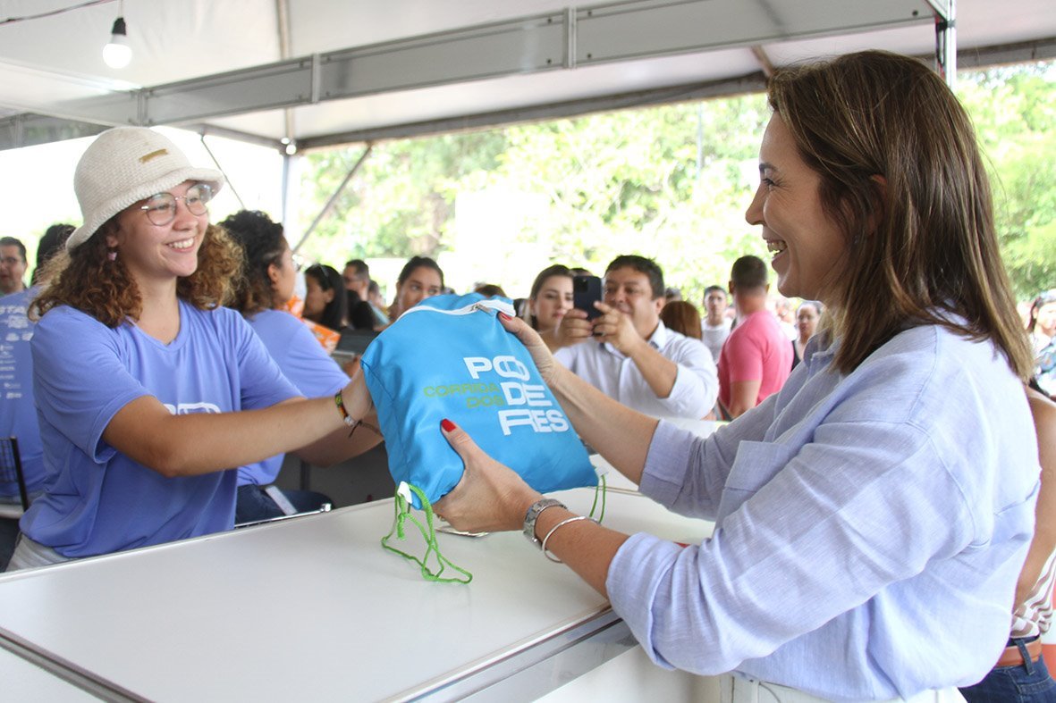 Mônica Riedel recebendo o kit para a Corrida dos Poderes.