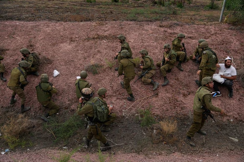 Soldados israelenses e civis se protegem após aviso sonoro de disparo de foguetes da Faixa de Gaza, em 9 de outubro. 
