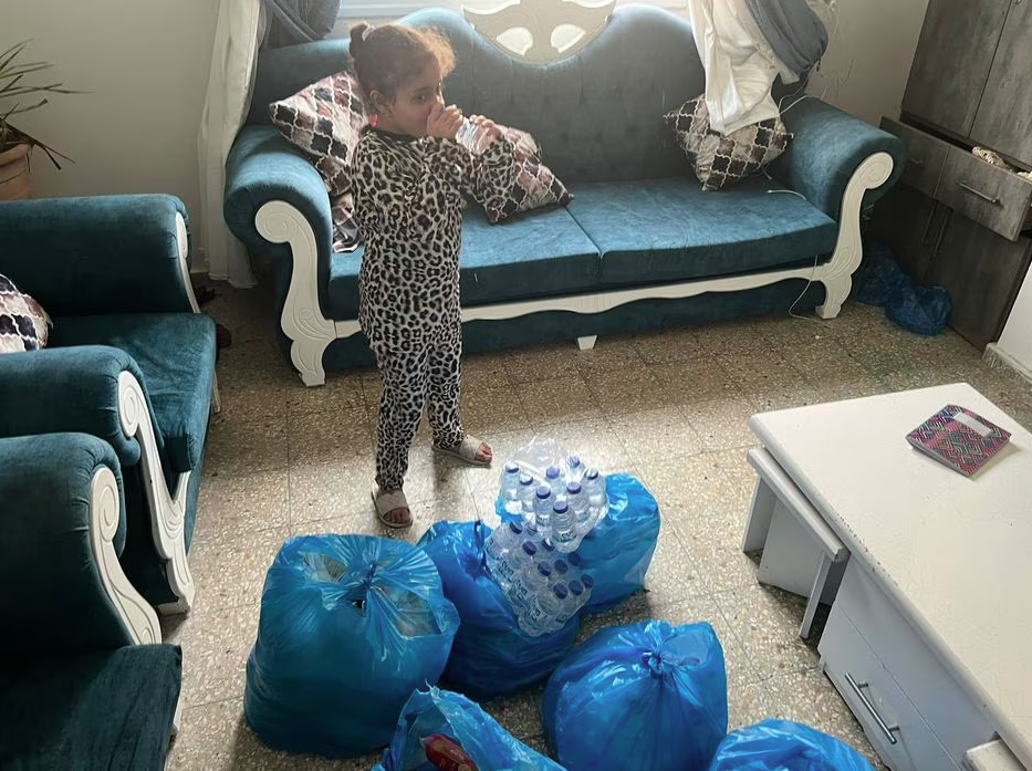 Filha do palestino com cidadania brasileira Hasan Rabee bebe água mineral conseguida com ajuda da embaixada do Brasil na Palestina.