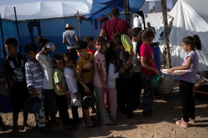 Crianças palestinas fazem fila por alimentos em Khan Younis, na Faixa de Gaza