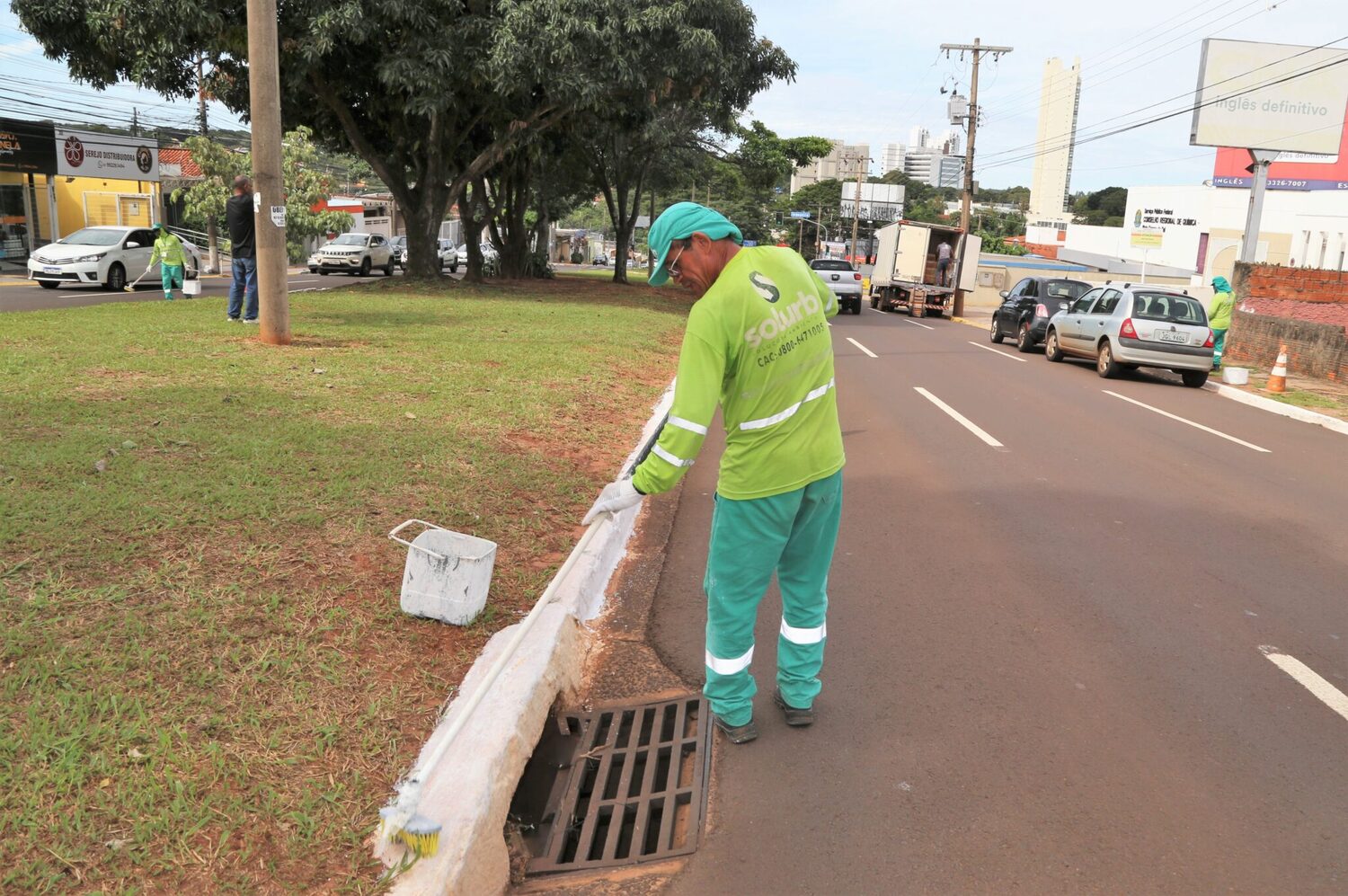 Profissional trabalha na pintura de meio fio 