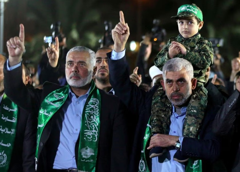 O chefe do grupo terrorista Hamas na Faixa de Gaza Yahya Al-Sinwar segura o filho de outro líder do Hamas, Ismail Haniyeh.