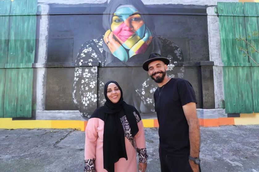 Imagem mostra palestina Noura Bader ao lado do artista Eduardo Kobra. Bader teve o rosto retratado em um mural do artista na zona leste de São Paulo