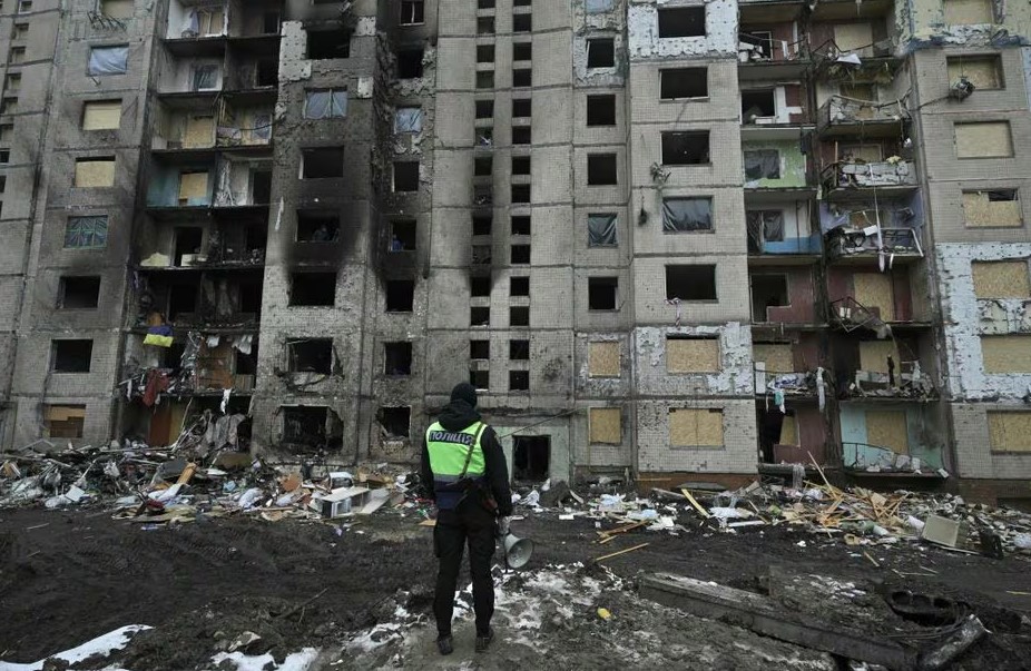 Um policial na frente de um prédio residencial muito danificado, três dias após um ataque de mísseis russos em Kiev, em 5 de janeiro de 2024, em meio à invasão russa na Ucrânia. 