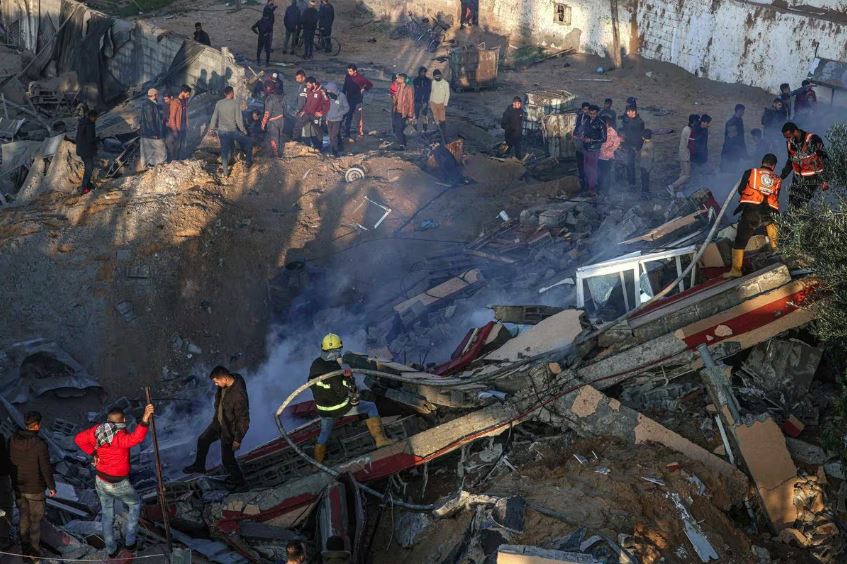 Palestinos contém incêndio em prédio destruído por bombardeios israelenses, Rafah, Faixa de Gaza, 19 de fevereiro de 2024