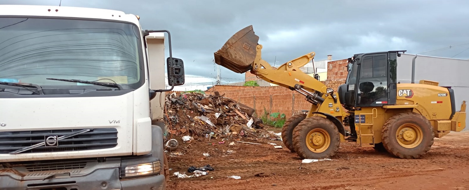 Retroescavadeira colocando lixo em um caminhão caçamba
