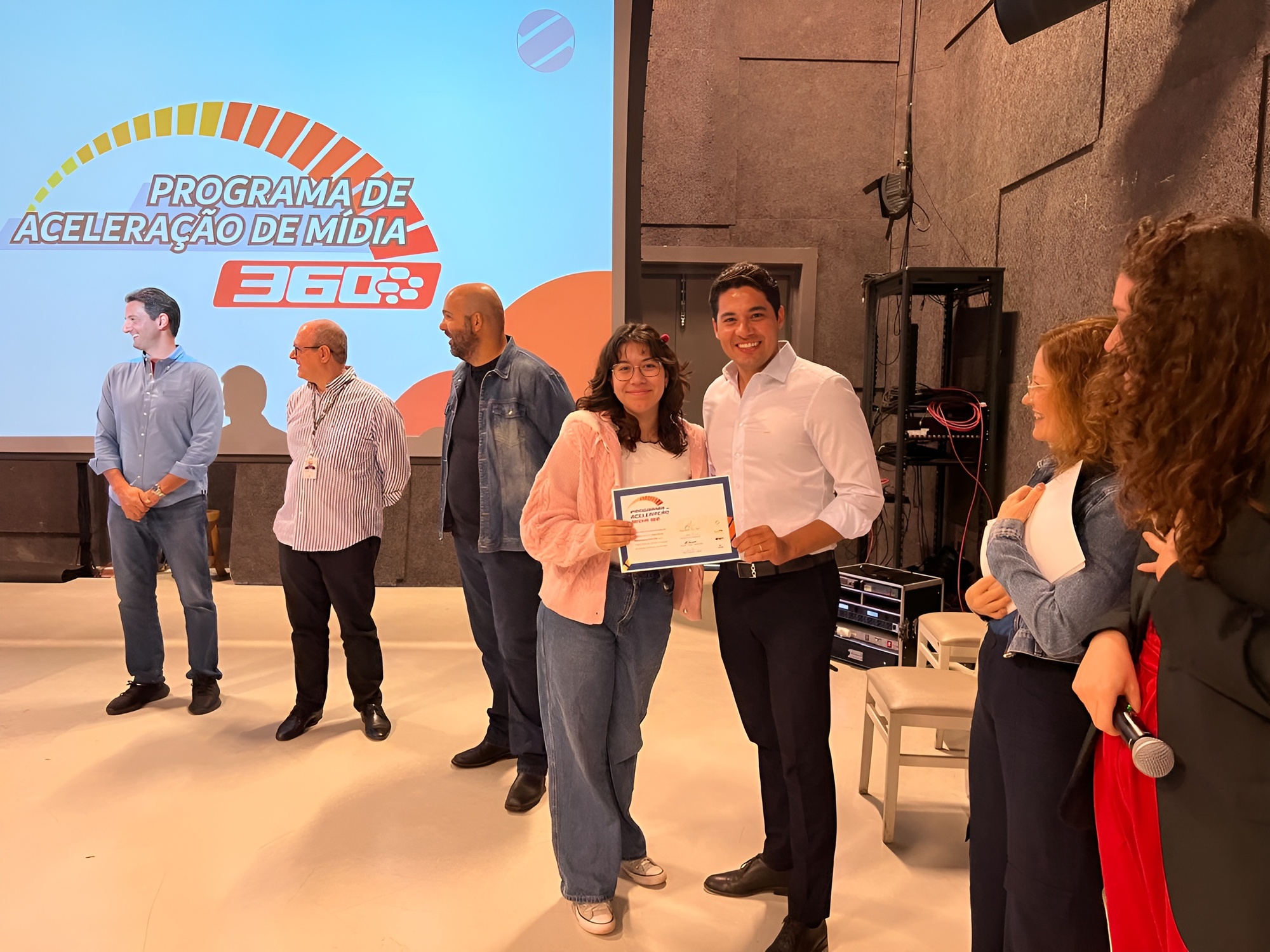 Eduarda Dutra de Oliveira recebeu o certificado de conclusão do programa das mãos do vice-presidente da Midiacom-MS, Enrico Feitosa.