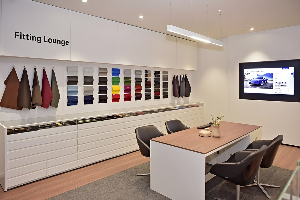 Fitting Lounge em concessionária Porsche espaço exclusivo onde clientes personalizam seus veículos com opções de acabamento e cores.