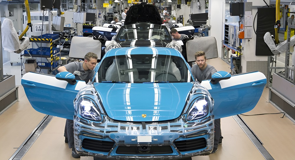 Modelo Porsche, já vendido, em fase final de montagem na linha de produção, com técnicos realizando os últimos ajustes.