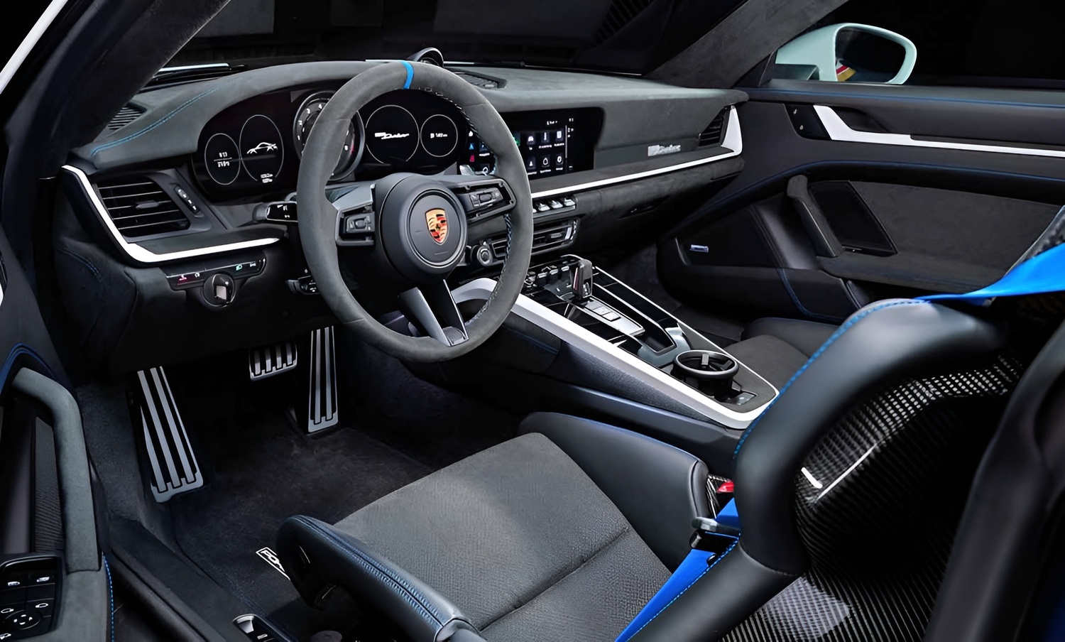 Interior do Porsche 911 Dakar combina design esportivo e sofisticado, com volante em Alcantara, painel digital com logotipo Dakar, pedais de alumínio e assentos em fibra de carbono, proporcionando condução confortável.