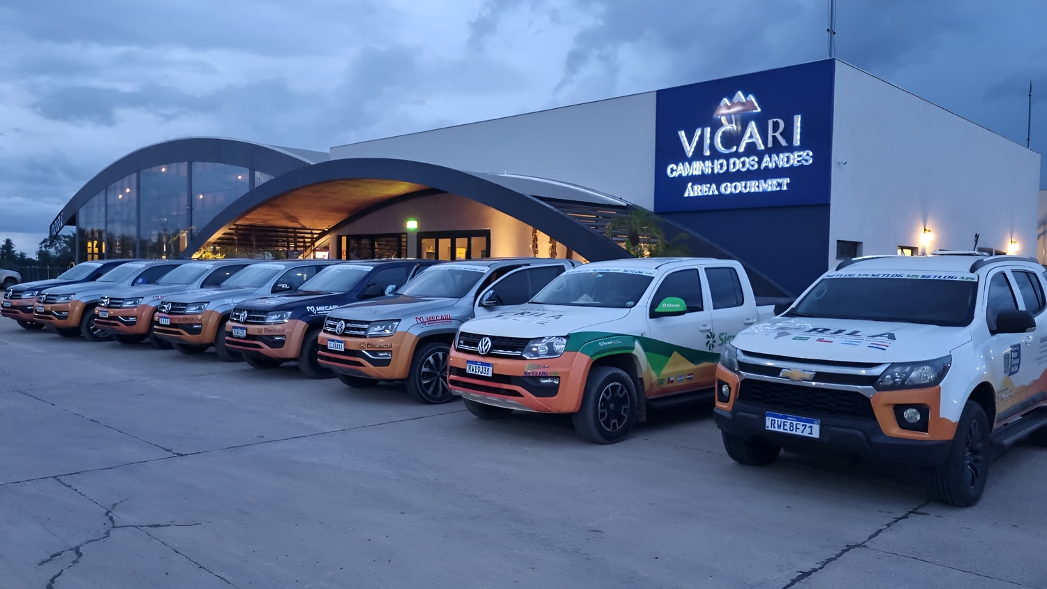 Veículos da expedição RILA estacionados em frente ao terminal Vicari, em Porto Murtinho, durante a etapa realizada em 24 de novembro de 2023. A expedição faz parte dos esforços de integração logística da Rota Bioceânica, conectando Brasil, Paraguai, Argen