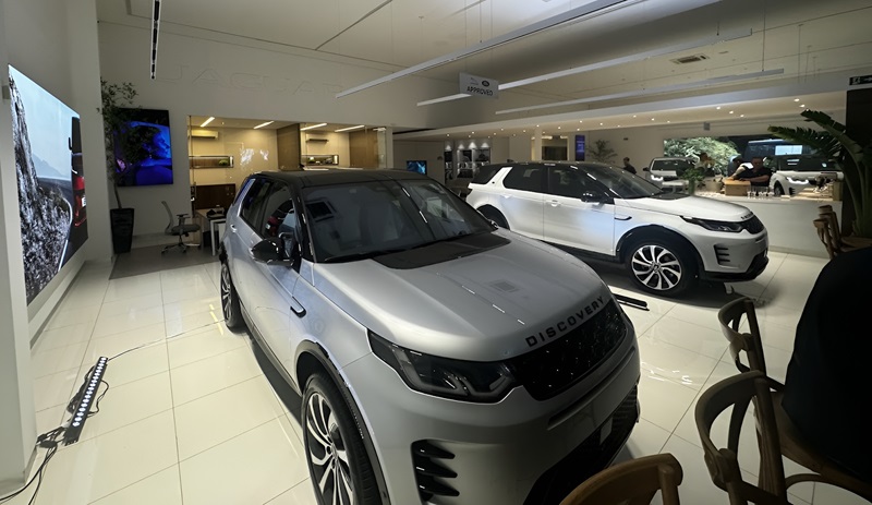  O showroom iluminado reflete a modernidade e a tradição dos modelos Land Rover, em destaque o Discovery Sport 2025.
