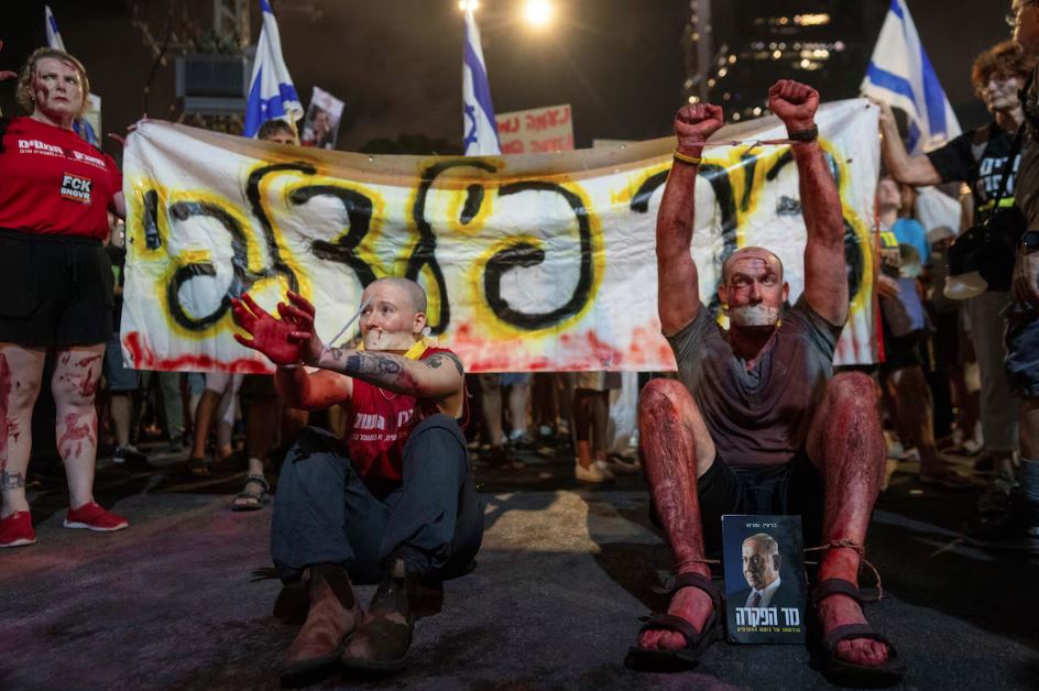 Ativistas usam sangue cenográfico, pulsos amarrados e a boca selada com fita, enquanto os parentes dos reféns mantidos por terroristas do Hamas na Faixa de Gaza e seus apoiadores pedem a libertação imediata e protestam contra o governo Netanyahu