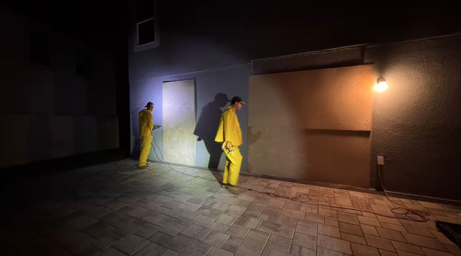 Funcionários instalam telas de madeira para proteção da casa da brasileira Juliana Furlan Zenti, em San Antonio, Flórida
