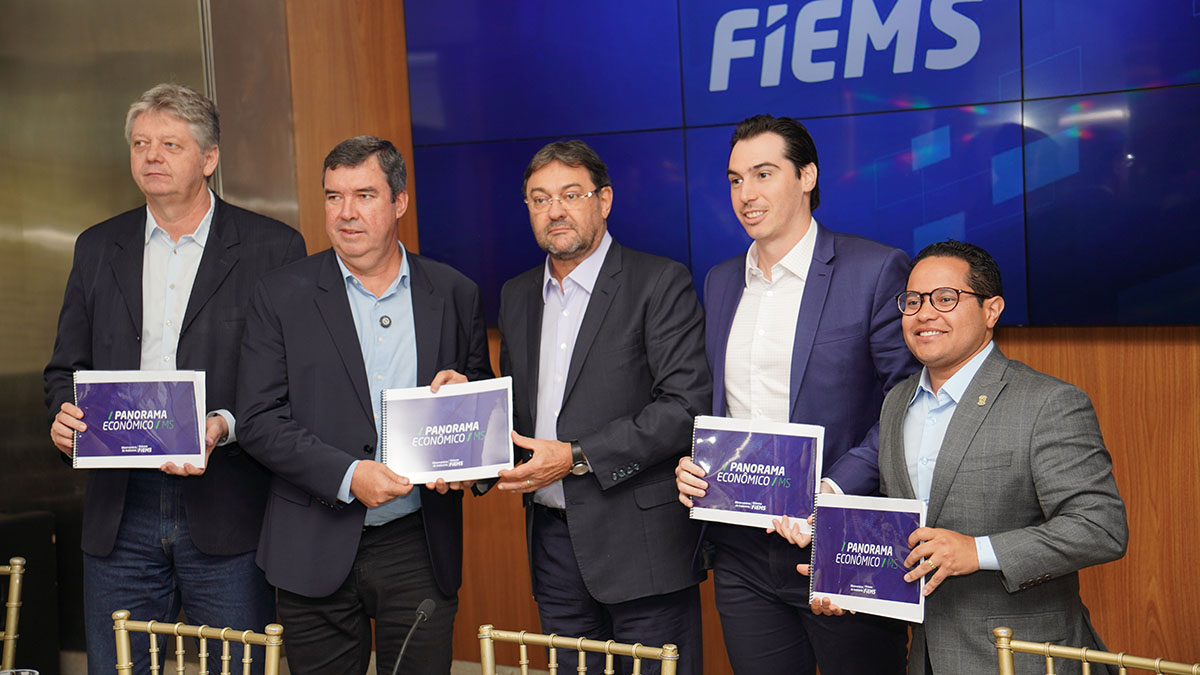 Governador Eduardo Riedel recebe relatório com panorama econômico da Fiems, acompanhado por secretários e autoridades estaduais.