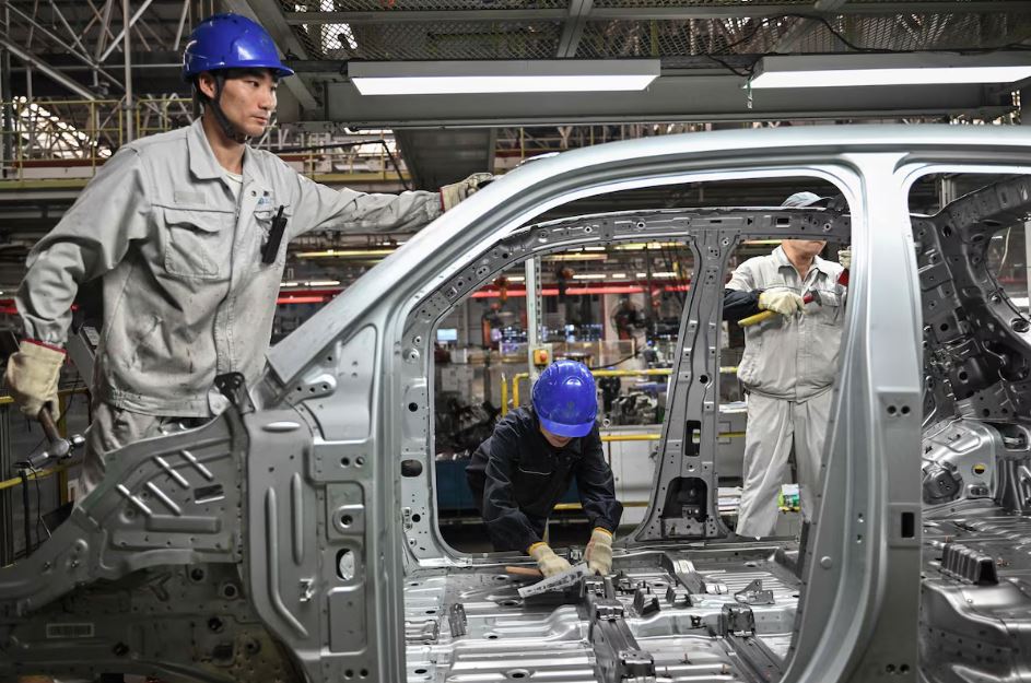 Imagem de setembro mostra trabalhadores chineses em uma fábrica de carros elétricos em Jinhua, em Zhejiang. Trump promete impor tarifas nos EUA contra produtos do país