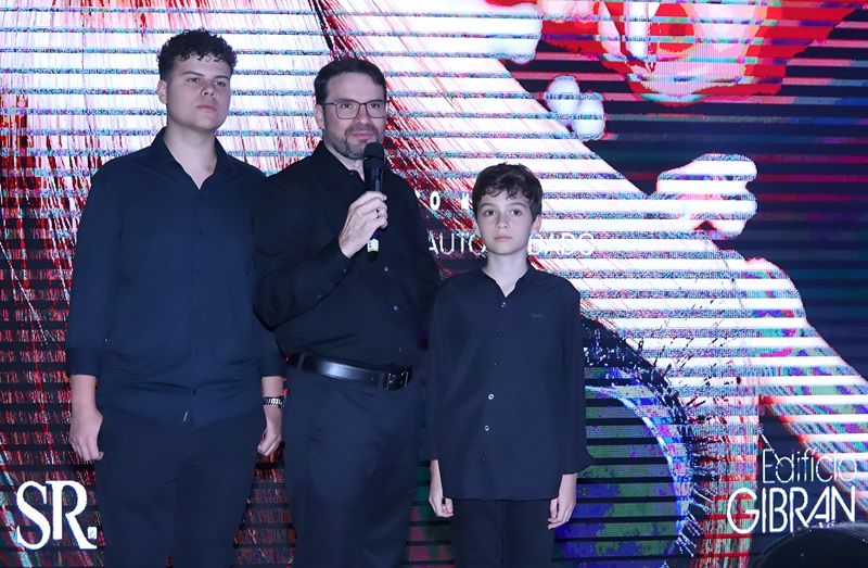 Jadir Saraiva, fundador da Saraiva de Rezende, ao lado de seus filhos durante a cerimônia de entrega do Edifício Gibran, celebrando o compromisso com a família e a qualidade.