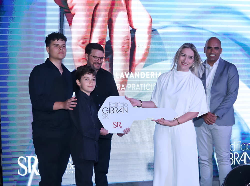 Lidiane Meneghetti Vieira, síndica do Edifício Gibran, recebe a chave simbólica das mãos da família de Jadir Saraiva durante a cerimônia de entrega.