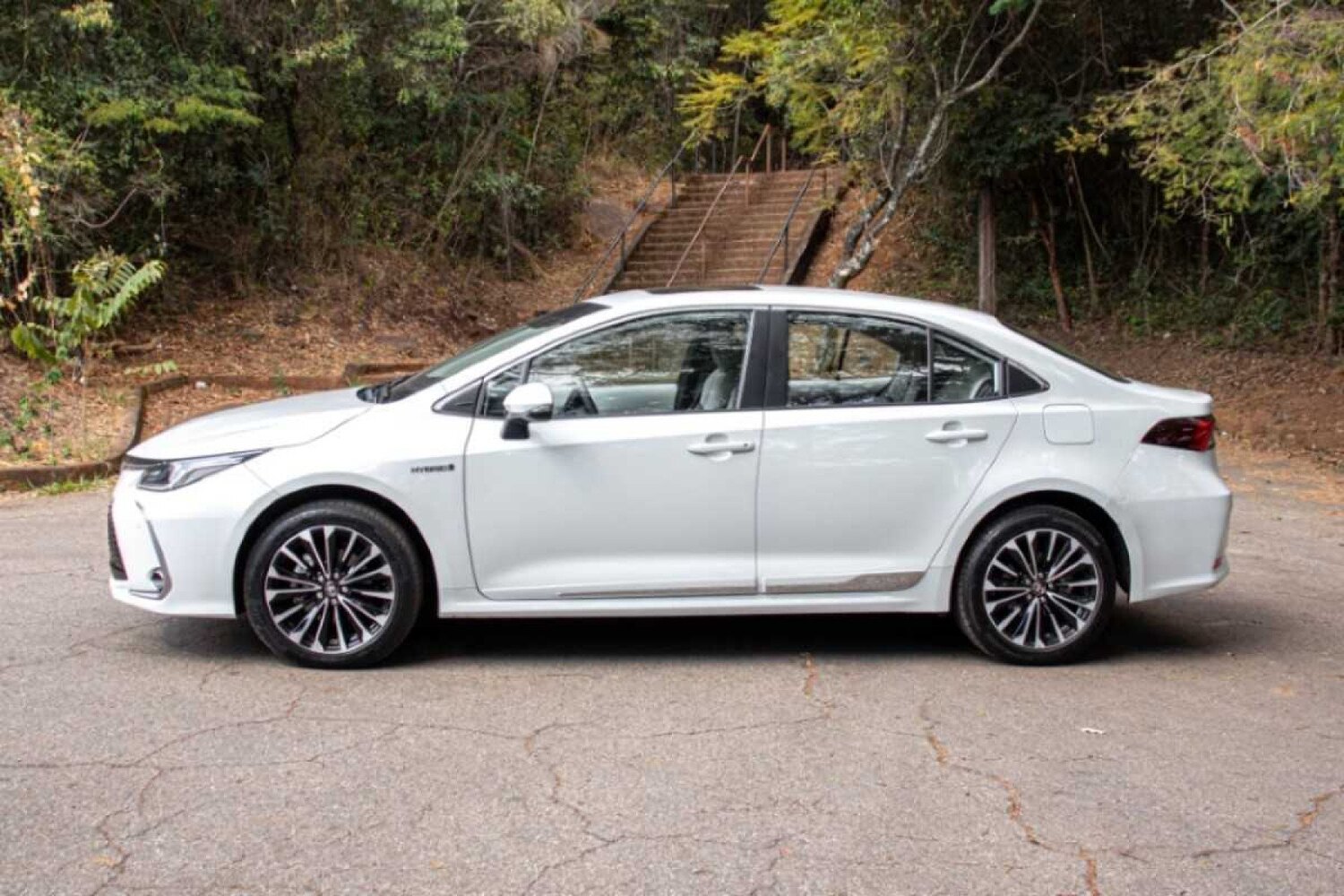 Toyota Corolla Altis Hybrid Premium 2025 visto de perfil: design elegante, linhas fluidas e rodas esportivas complementam a sofisticação do sedã.