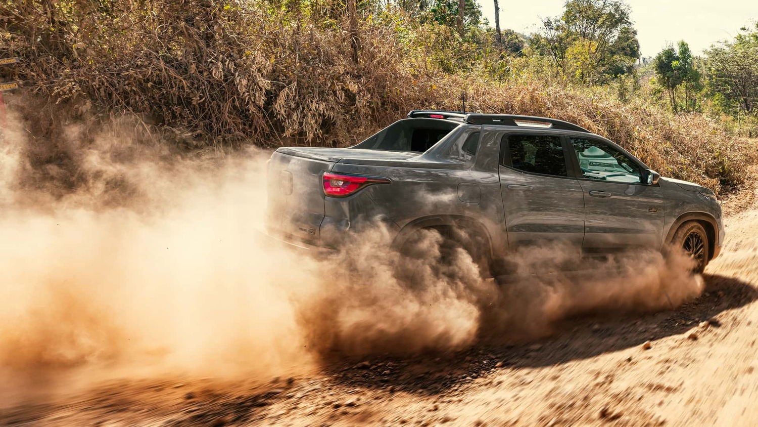 A Fiat Toro Ultra encara terrenos desafiadores, destacando sua robustez e design arrojado em meio à poeira.