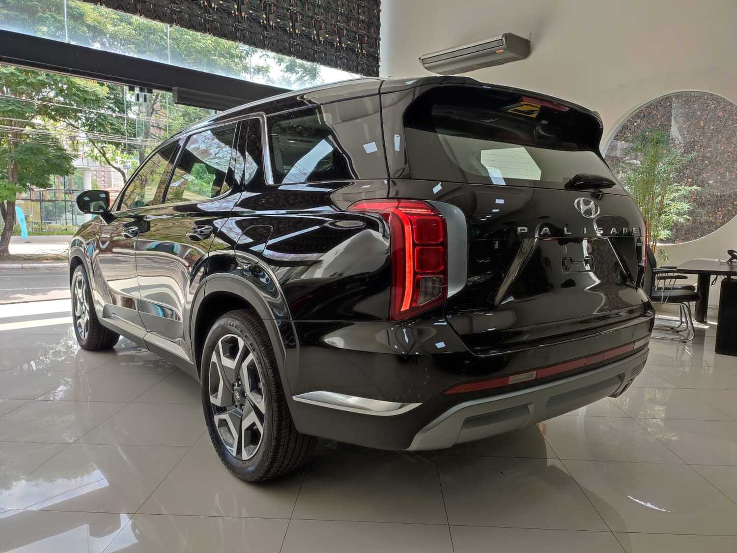 Traseira do Hyundai Palisade, SUV de luxo da marca sul-coreana, exibindo seu design robusto e acabamento refinado em um showroom.