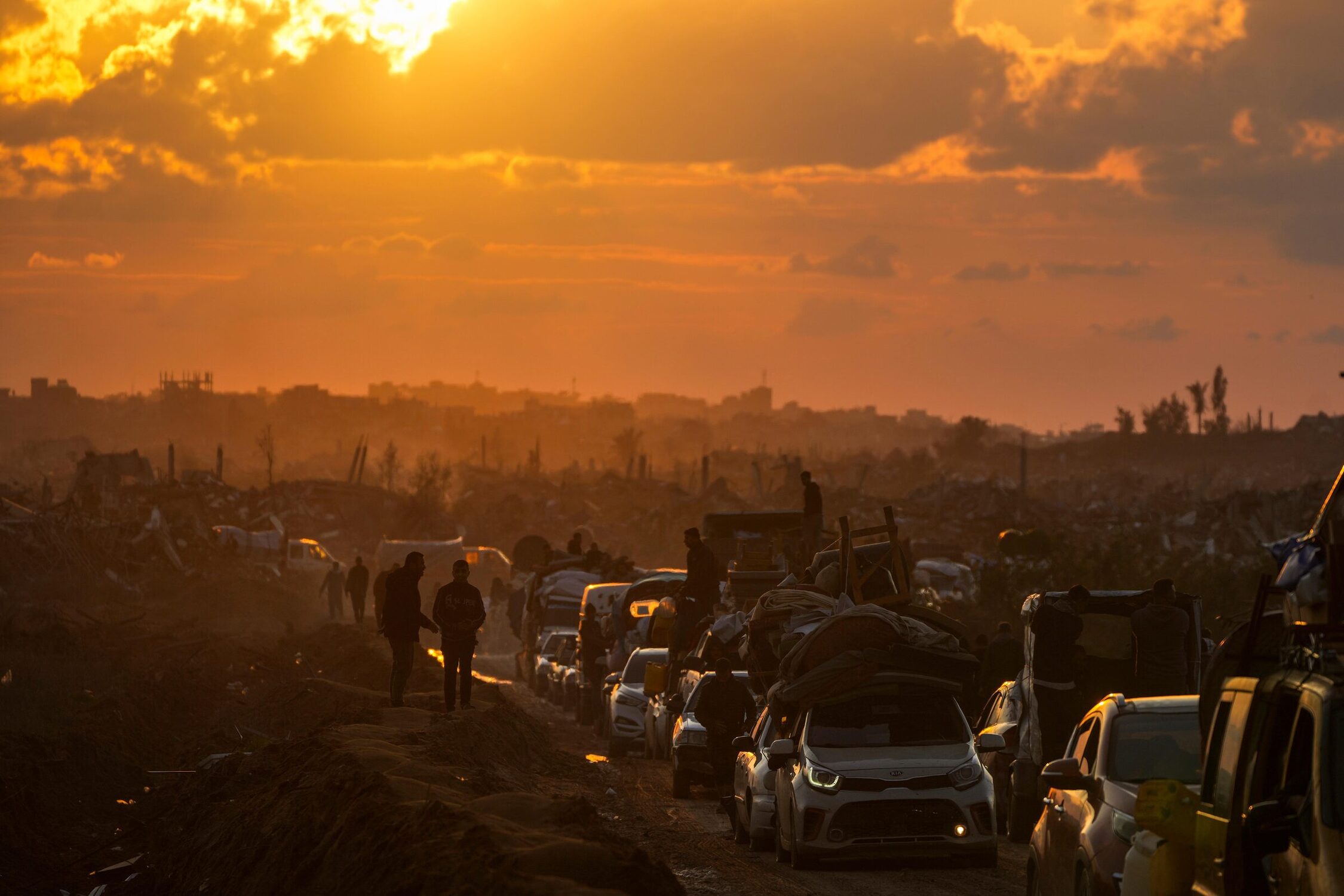 Palestinos deslocados esperam na fila de carros para passar por um posto de controle de segurança no corredor Netzarim enquanto seguem do centro de Gaza para suas casas no norte.