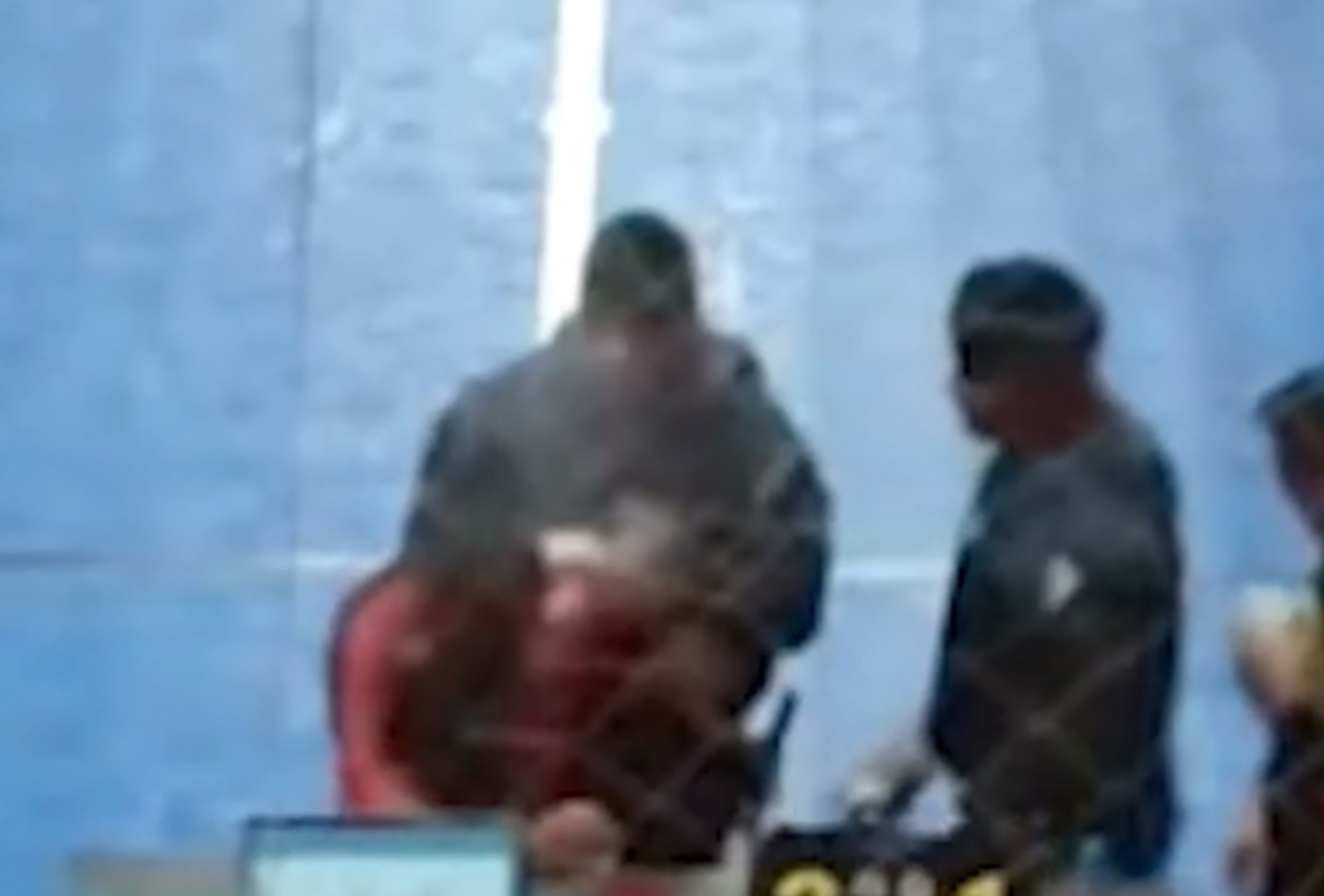 Momento em que o treinador é retirado da quadra por agentes da PM após uso de spray de pimenta, em torneio infantil