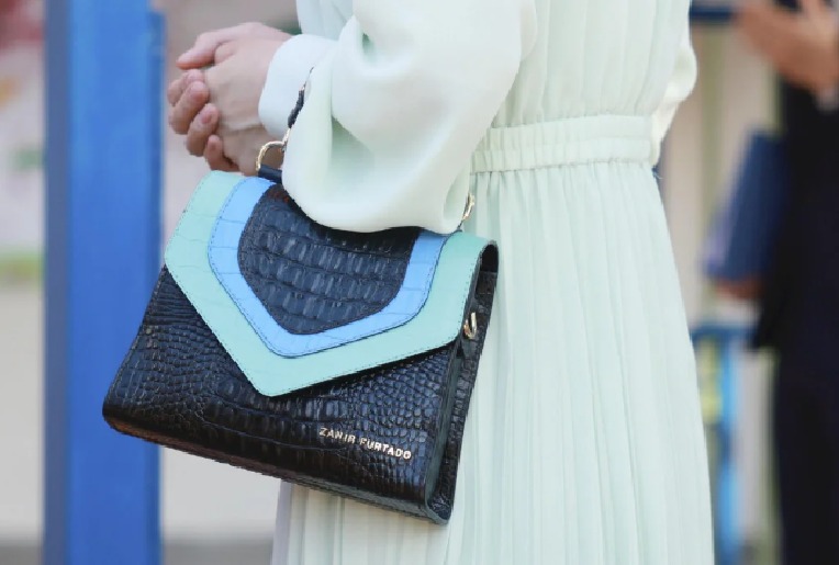 Modelo Diva, da marca Zanir Furtado, confeccionado em couro preto com detalhes azul-turquesa inspirados no Pantanal