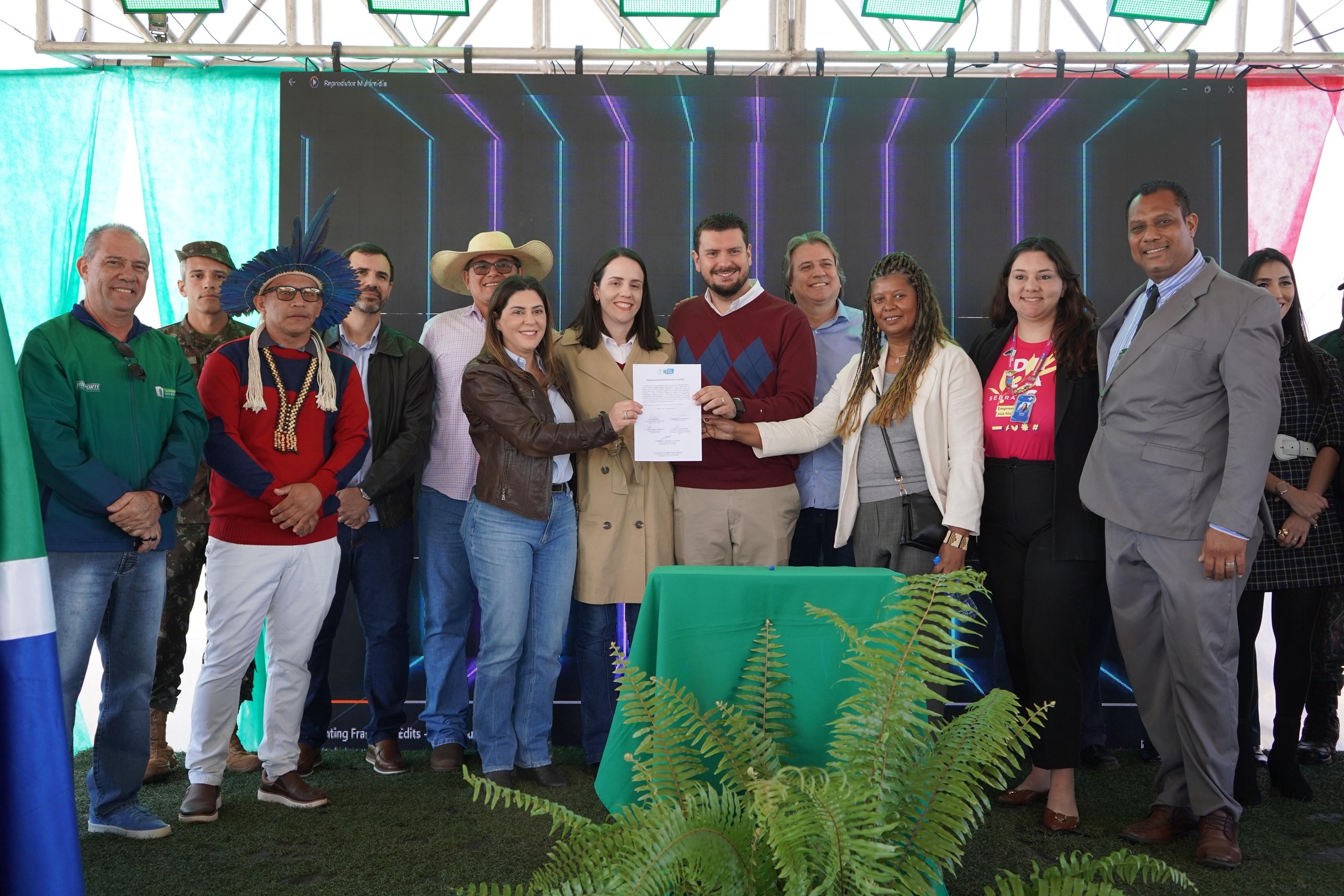Prefeito André Guimarães entrega documento de parceria durante evento em Nioaque, ao lado de autoridades, lideranças indígenas e representantes de instituições.